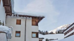 a building covered in snow with icicles on it at Chesa Sarvit 1 - Trilocale in Celerina +17 photos