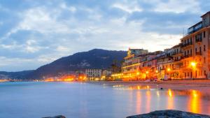 a city with buildings and a lake at night at Terrazza d'Amare - Alassio Centro in Alassio
