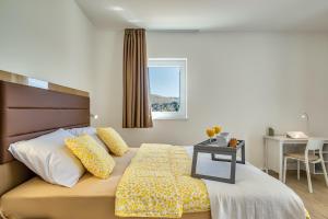 a bedroom with a bed with a table and a window at Vila Katarina by Resort Čulina in Metajna +105 photos
