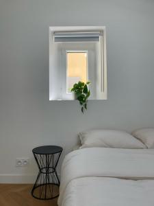 a bedroom with a bed and a window with a plant at Duplex Place Garibaldi - Close to port, Old Nice in Nice