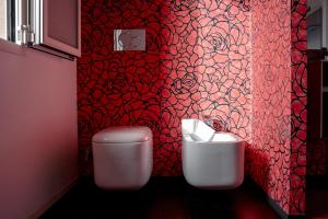 a red bathroom with a toilet and a sink at LE SITE in Specchia