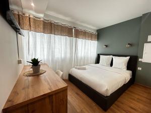 a bedroom with a large bed and a wooden table at La Suite Auzette, calme et chic in Panazol