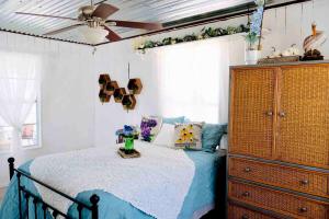 GunterCharming Lake Fork Cabin in East Texas near Dallas的一间卧室配有一张带吊扇和梳妆台的床。