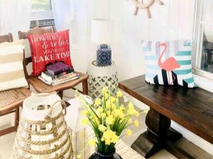 GunterCharming Lake Fork Cabin in East Texas near Dallas的客厅里有一张长凳和一张摆满鲜花的桌子