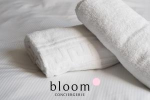 a roll of white towels on a bed at Appartement de Standing Neuf in Nancy