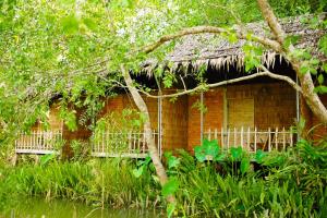 a bamboo house with a thatch roof at Dan Sinh Homestay in Can Tho
