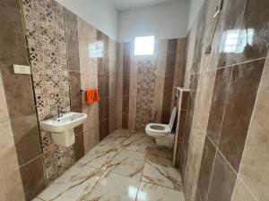 a bathroom with a toilet and a sink at Résidence Mabrouka in Qaşr Chouline