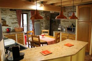 a kitchen with a counter and a table in it at Les 3 Ours in Couflens