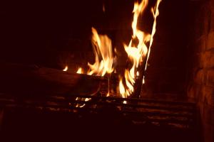 a fire in a brick fireplace at night at Hotel Ika Mirador Suesca in Suesca