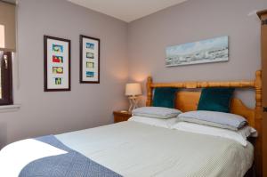a bedroom with a bed with two pillows at Dolphin Run in Hunters Quay