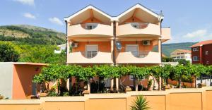 a building with trees in front of it at Apartments Vuksanovic in Tivat