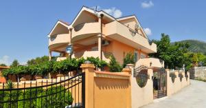a house with a fence in front of it at Apartments Vuksanovic in Tivat
