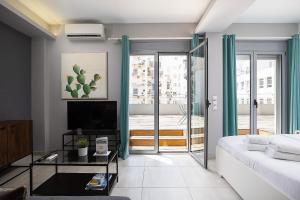 Una sala de estar con un sofá y un televisor en The Omnia Collection Pagrati, en Atenas 32 fotos más