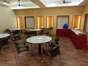 ein Konferenzraum mit Tischen und Stühlen und einem Tisch mit in der Unterkunft Hotel Aramdham in Jāmb