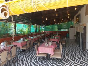 ein Restaurant mit rosa Tischen und Stühlen in einem Zimmer in der Unterkunft Hotel Aramdham in Jāmb