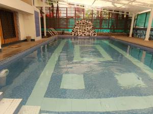 ein Schwimmbecken mit einem Stuhl in einem Gebäude in der Unterkunft Hotel Aramdham in Jāmb