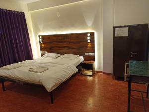 ein Schlafzimmer mit einem großen Bett und einem Tisch in der Unterkunft Hotel Aramdham in Jāmb + 16 Fotos
