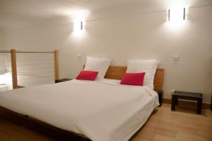 ニースにあるApartment Massena - Old Townのベッドルーム1室(白いベッド1台、赤い枕2つ付)