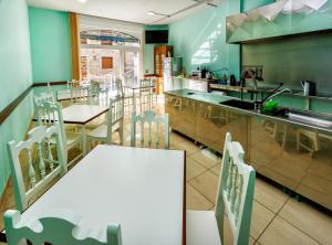 una cucina con tavolo, sedie e bancone di Albergue Arribada a Muxia