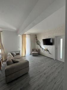 a living room with a couch and a flat screen tv at David Apartament in Buzău +9 photos