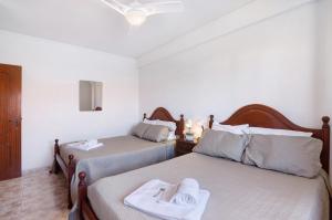 a bedroom with two beds with towels on them at Apartamento Pescadores in Monte Gordo