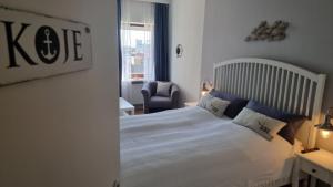 a bedroom with a large white bed with blue pillows at Ferienwohnung Wattkieker inklusive Strandkorb in Büsum