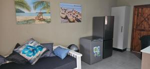Una sala de estar con un sofá y un refrigerador. en Bella Vida, en Matango