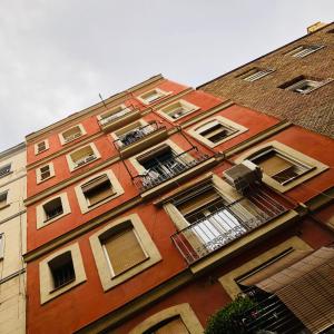 Edificio alto de ladrillo rojo con ventanas y balcones en Habitación privada junto al mar en la Barceloneta, en Barcelona