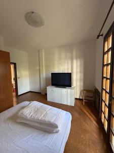 a bedroom with a bed and a flat screen tv at Giardinetto Apartment in Lido di Jesolo