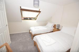 a small room with two beds and a window at Margherita in Wroxham