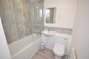 a bathroom with a toilet and a sink and a shower at Margherita in Wroxham +10 photos