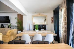 ein Esszimmer mit einem Tisch und weißen Stühlen in der Unterkunft Villa Bella Vista - Calme, Spacieuse et Standing in Grabels