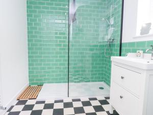 a bathroom with green subway tile and a shower at 3 Glyn Y Mor in Pwllheli +22 photos