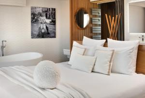 una camera con letto bianco e vasca da bagno di Villa Miramar Frontignan a Frontignan