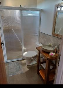 y baño con ducha, aseo y mesa. en Depto La Porteña a 1k Termas, en Gualeguaychú