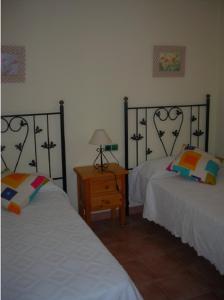 una habitación con dos camas y una mesa con lámpara en Las Palmeras Golf II, en Lepe