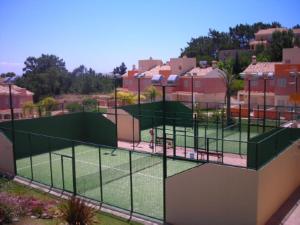una cancha de tenis con una red en una cancha de tenis en Las Palmeras Golf II, en Lepe