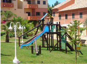 un patio de recreo con un tobogán en un parque en Las Palmeras Golf II, en Lepe
