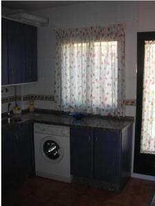 cocina con lavadora y ventana en Las Palmeras Golf II, en Lepe