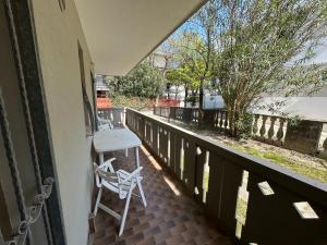 a balcony with a table and a chair on it at Anthea - Timavo apartament 1 in Lignano Sabbiadoro