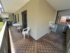 a balcony with two chairs and a table and a table at Anthea - Timavo apartament 1 in Lignano Sabbiadoro +1 photo