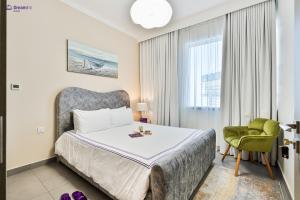 a bedroom with a bed and a chair and a window at Dream Inn Apartments - Dubai Creek Harbour in Dubai