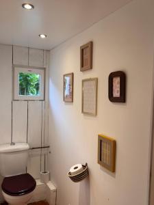 a bathroom with a toilet and pictures on the wall at Motel - Usine à Gaz in Bourgueil +44 photos