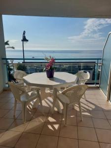 a white table and chairs on a balcony with the ocean at Atelier Sonia in Roquebrune-Cap-Martin +46 photos