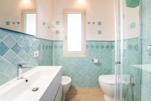 a bathroom with a white sink and a toilet at Casa Smeralda, Vista Mare Sea View in Fort Village