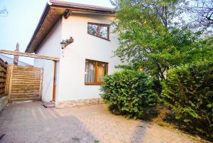 una casa blanca con una puerta y árboles en Retreat Drumul Vinului-Odobesti, en Boteşti