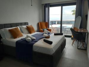 una camera da letto con un grande letto con sedie e un balcone di HOTEL ANDREAS a Ipsos