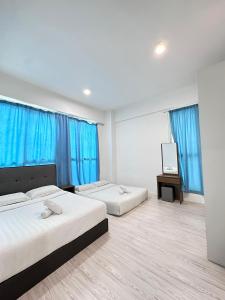 two beds in a room with blue curtains at reSTARY K-PLAY Themed Staycation in Kota Kinabalu