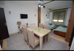 a dining room with a table and chairs and a bedroom at Centar in Vrnjačka Banja