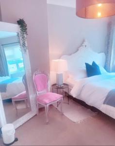 ein Schlafzimmer mit einem Bett, einem Spiegel und einem Stuhl in der Unterkunft 3 Bedroom house in Dublin in Lucan